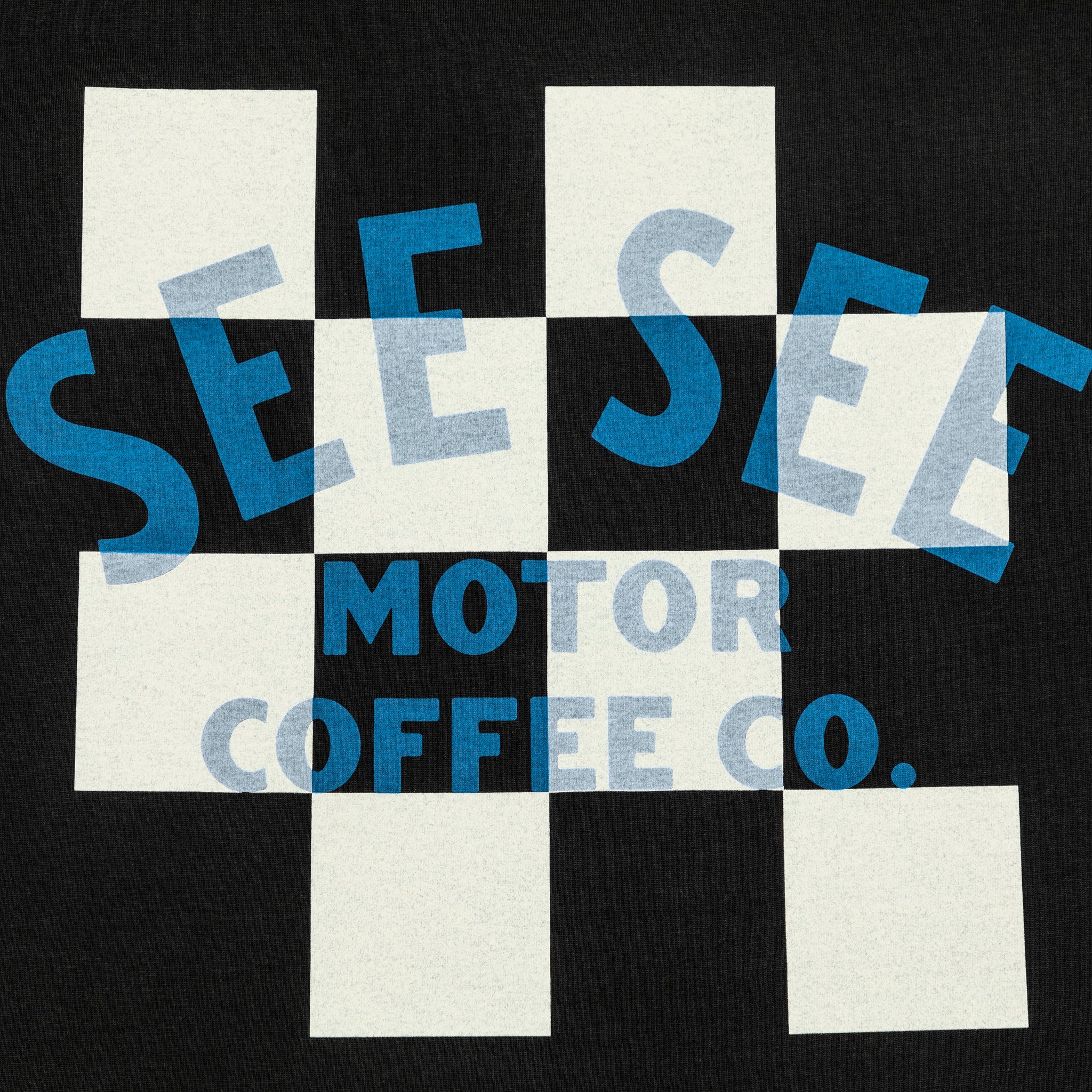 Detail shot of black unisex t-shirt with white and black checkered center on the back. Blue See See Motor Coffee Co. text overlay.