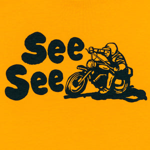 Front detailed shot of black illustration of a motorcyclist. Text to the left of the motorist reads, See See.