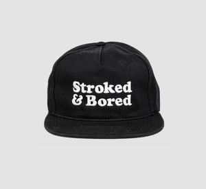 Front shot of black cotton unisex 5-panel hat. Centered text in white embroidery reads Stroked & Bored. 