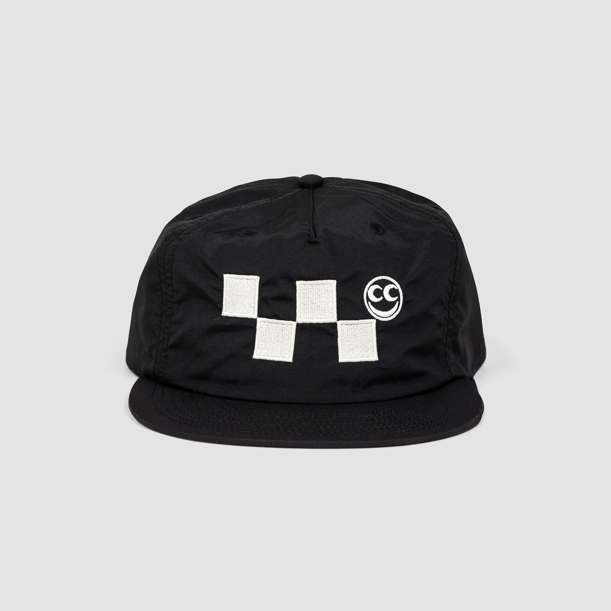 Front shot of black unisex adult surf-style 5-panel hat. White checkered embroidery graphic with white Vern smiley face centered along the front panel of hat.  