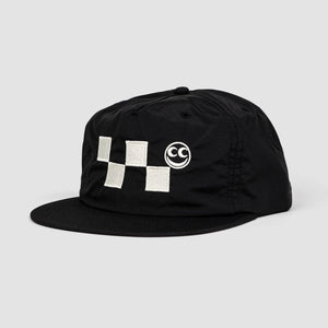 Side angle shot of black unisex adult surf-style 5-panel hat. White checkered embroidery graphic with white Vern smiley face centered along the front panel of hat.  