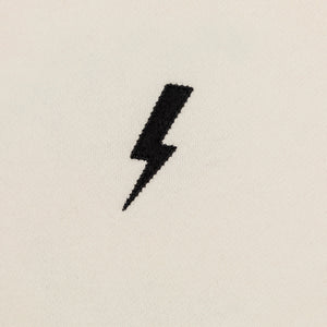 Front detailed shot of embroidered black lightning bolt.
